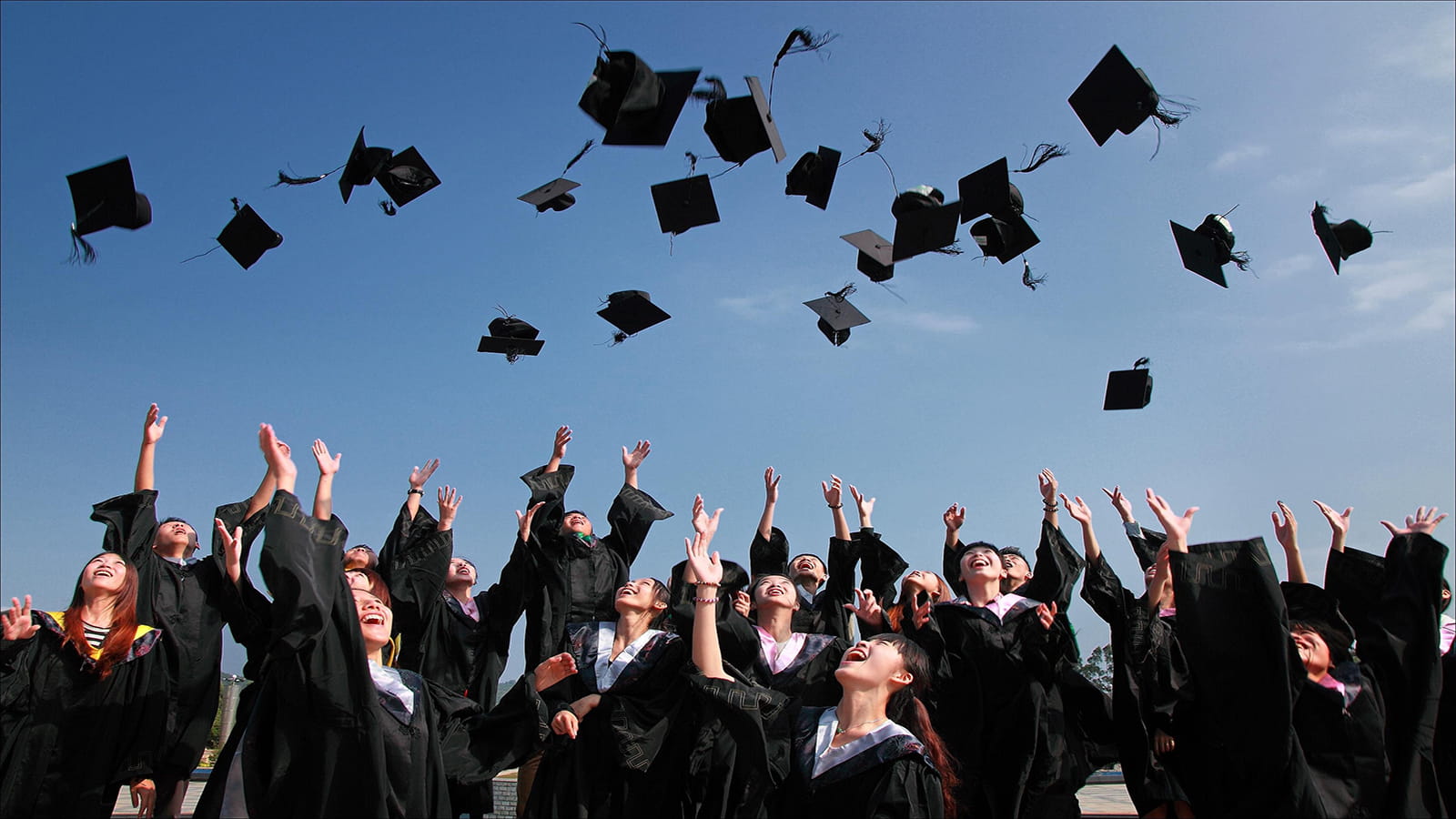 group of people graduating throwing their hats in the air