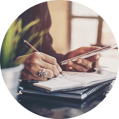 A close up of a woman writing down notes.