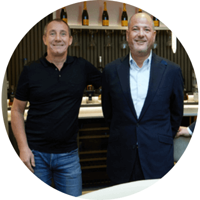 A group of three men standing smiling in front of a fancy bar.