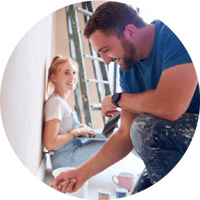 A man and a woman smiling whilst decorating.