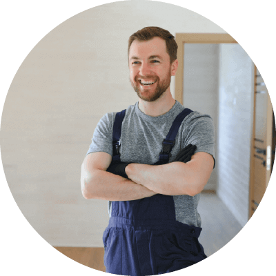 A man smiling in decorating clothes with his arms crossed.