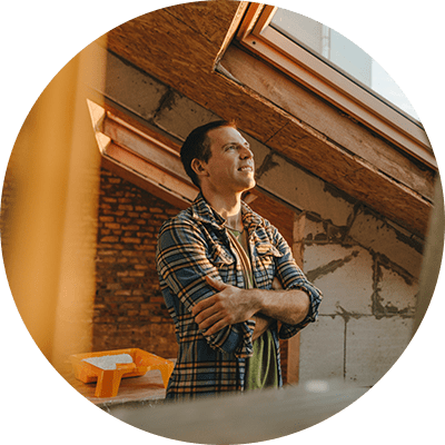 A man smiling looking out of a sky window in a loft.