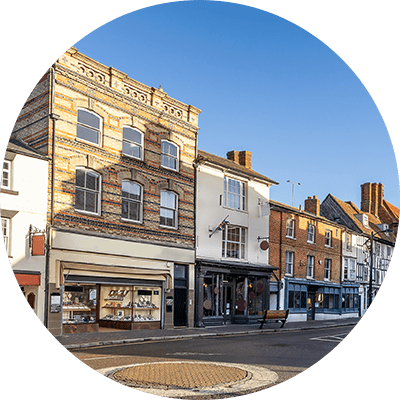 A wide shot of a busy high street with a lot of semi commercial properties down it.