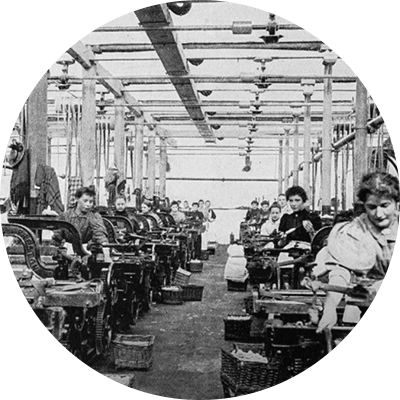 A black and white wide shot of lined up women working.