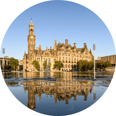 A long shot of a brick cathedral with a clock on it.