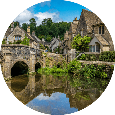 Blue skies and reflections in the picturesque Cotswold village of Castle Combe.