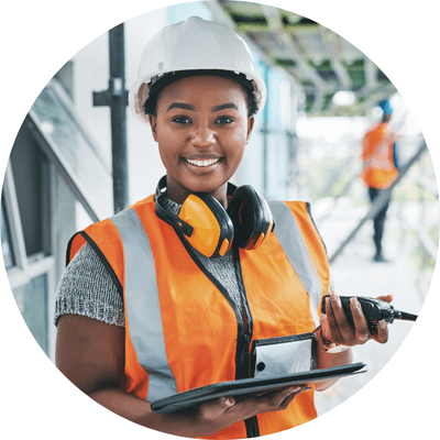 Female builder on site in hi vis vest and white hat.