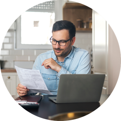 A middle aged landlord in his kitchen reviewing his rental portfolio ahead of refinancing and consolidating multiple loans. 