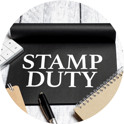 The word Stamp Duty written on a black mouse mat, surrounded by office items such as a notepad, pen and calculator.
