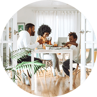 family with a young child sat round a table eating in a modern house