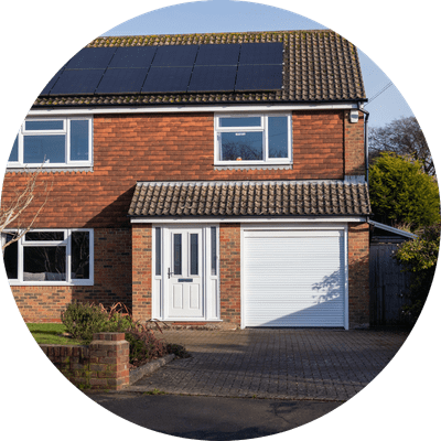 A typical suburban house with an attached garage and solar panels on the roof.