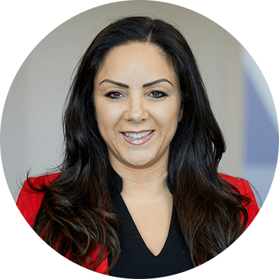 A woman with black hair smiling wearing a red blazer and black blouse.