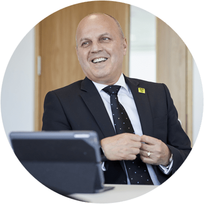 Man in three piece suit looking off camera laughing
