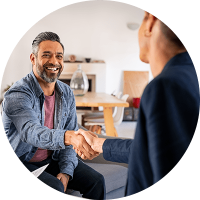 Two men sat down shaking hands.
