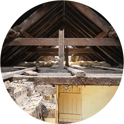 A ripped out attic with rubble everywhere.
