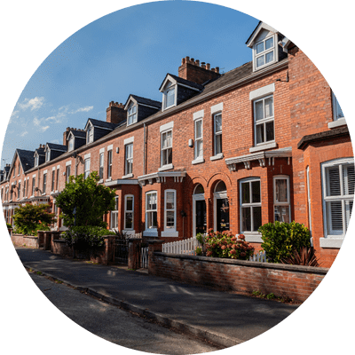 Row of attractive red brick terraced houses on a typical UK street on a bright sunny day.