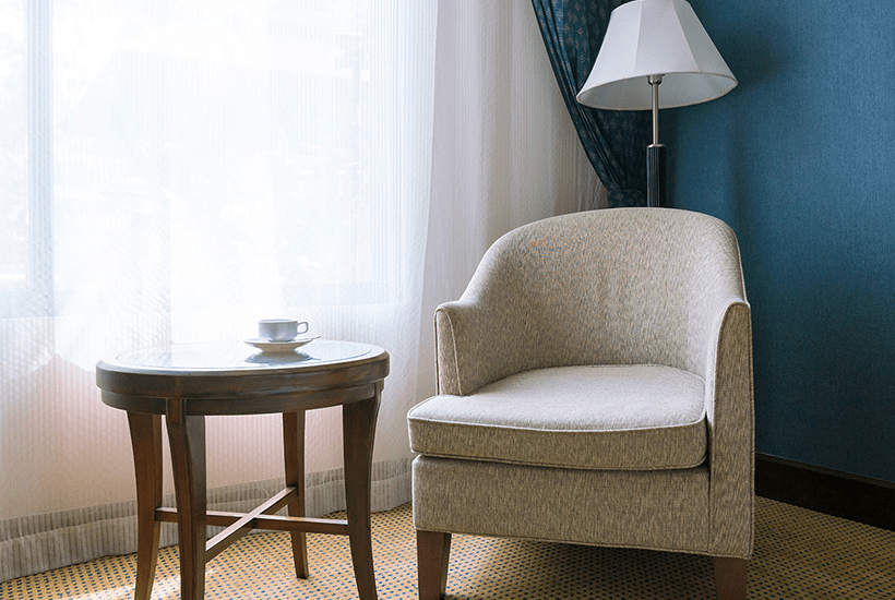 low back chair next to a dark wooden round table - l