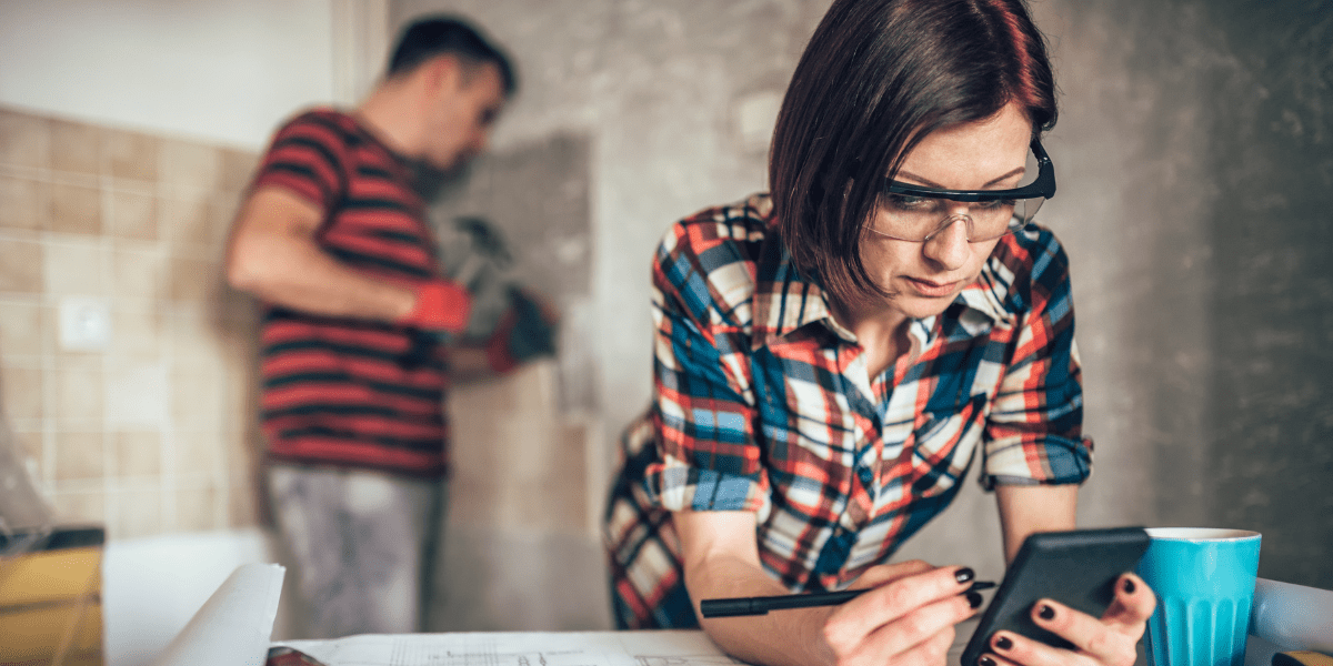 A young couple carrying out a refurbishment in a room within a house.