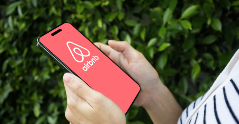 Young woman looking at the airbnb app on a mobile device.
