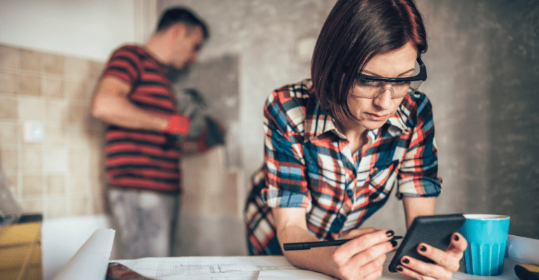 A young couple carrying out a refurbishment in a room within a house.