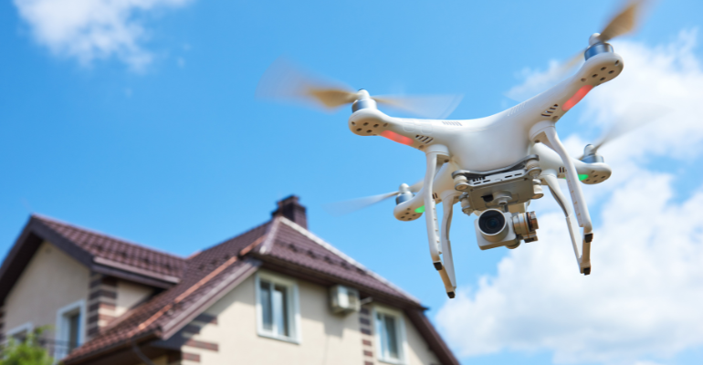 Drone being used for a house survey flying over a house.