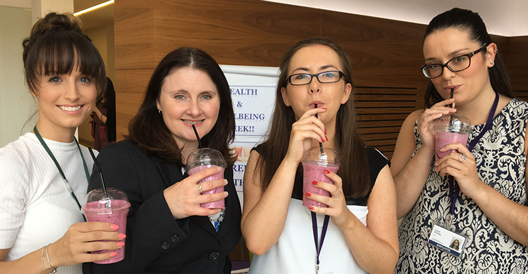 four girls holding pink smoothies - l