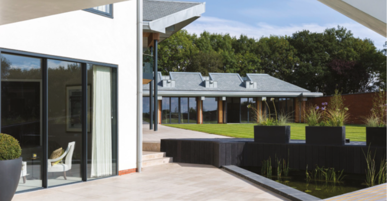Exterior of a luxury house showing the patio and garden.