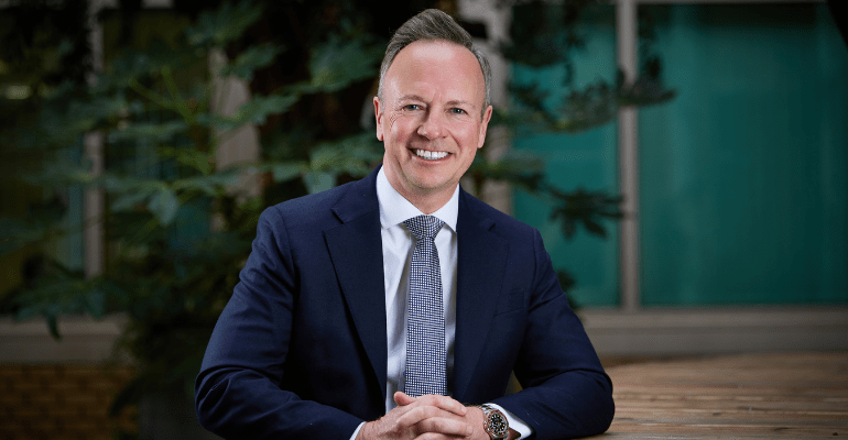 Mark Eastwood, Director of Corporate Sales at Together. A blue suited middle aged gentleman sitting and smiling warmly.