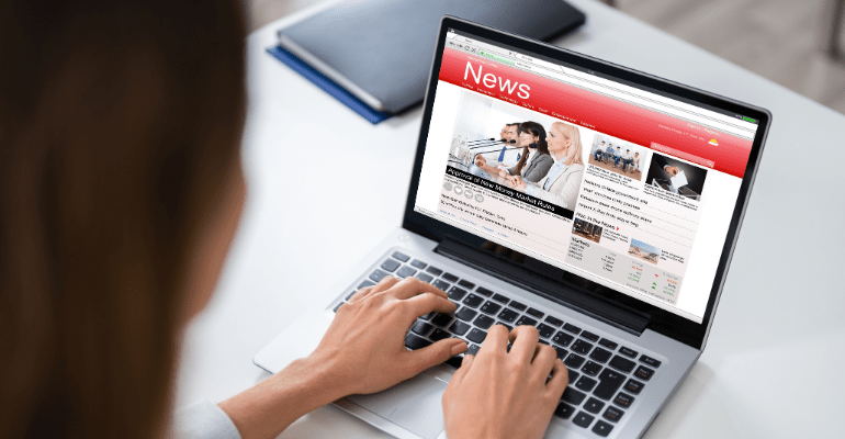 A woman reading the latest property news on a laptop.