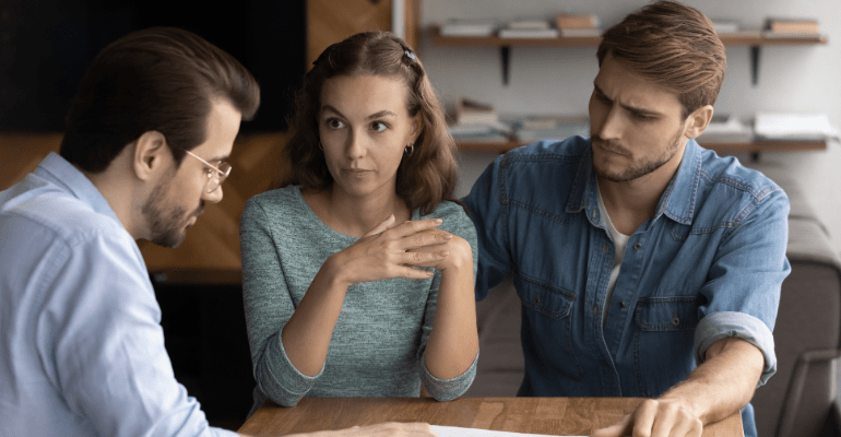 An unhappy young couple are talking with their landlord.