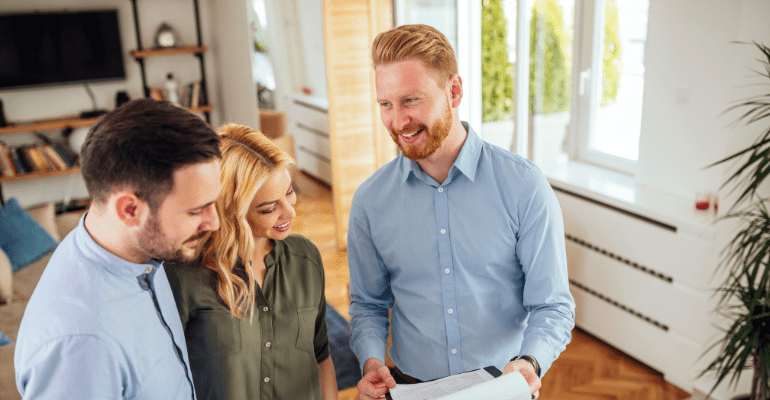Happy young tenant couple meeting with their young professional landlord in a well lit stylish room.