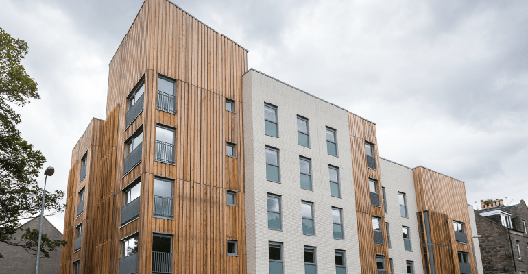 Multi-story wood panelled flats.