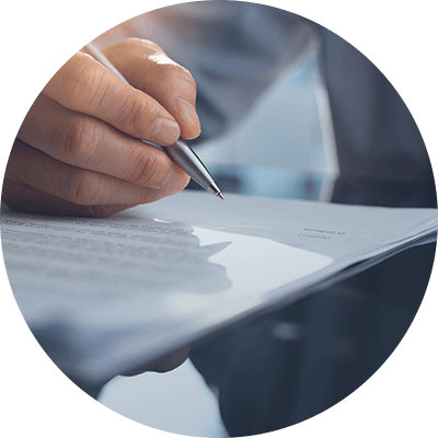 Someone with a pen in their hand writing on a document - 50