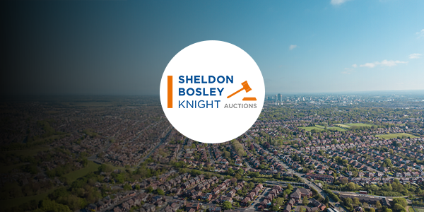 A birds eye view of Manchester with a Sheldon Bosley Knight logo over it.