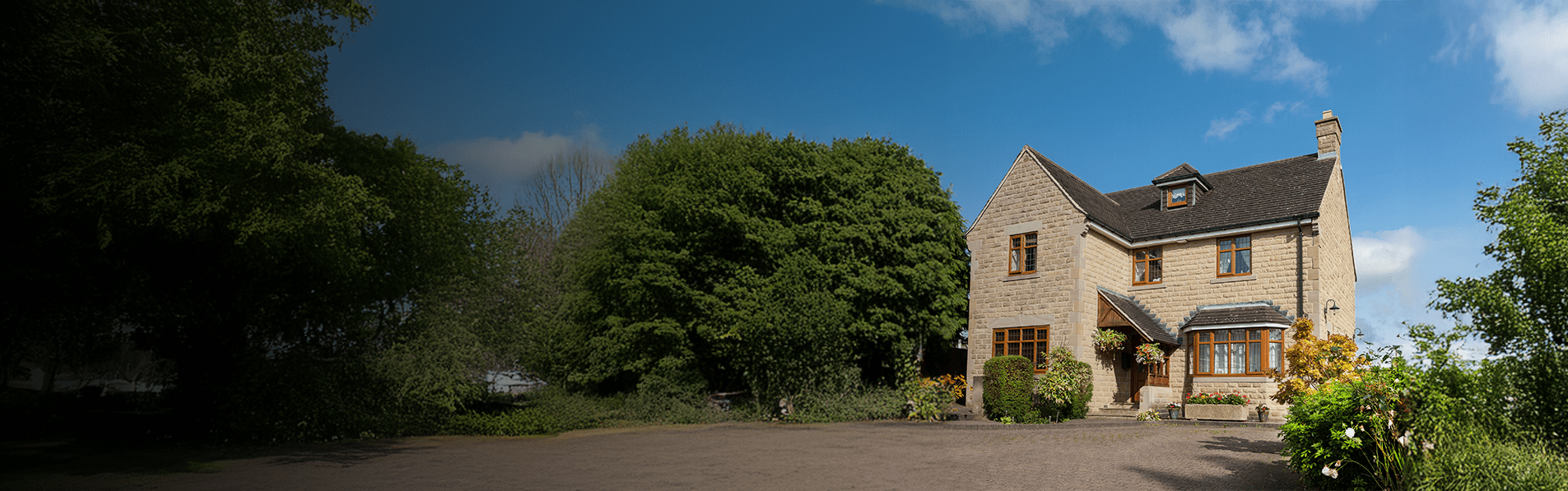 A wide shot of a detached house with a drive.