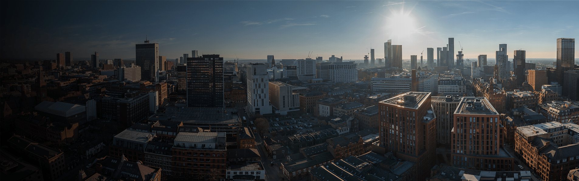 A wide shot of Manchester city centre with a sunrise.