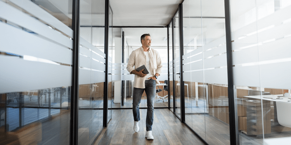 A man walking down an office hallway.