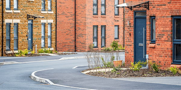 A wide shot of a street with different styled houses on there.