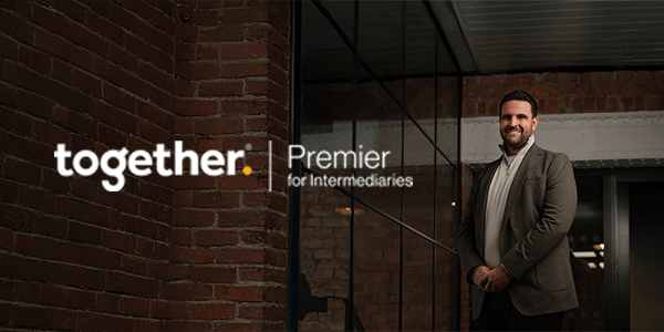 Dan Narwal standing in a modern brick warehouse smiling with a Together Premier Intermediaries logo.
