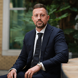 John Barker with short brown hair smiling sat down.