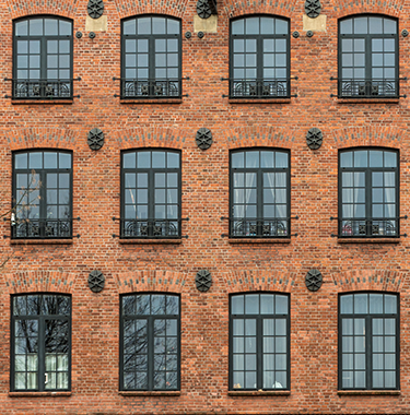 A wide shot of a modern brick building with black windows.
