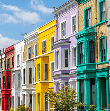 A wide shot of colourful terraced houses on a street.