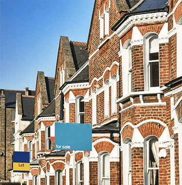 A wide shot of terraced houses with to let signs outside of them.