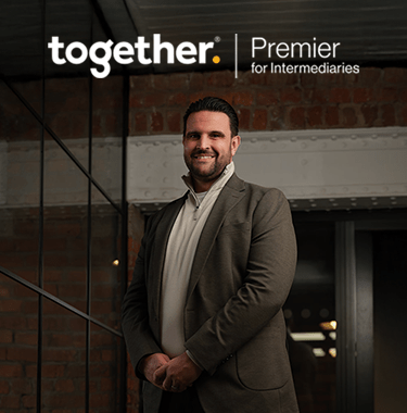 Dan Narwal standing in a modern brick warehouse smiling with a Together Premier Intermediaries logo.