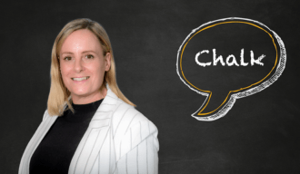 A woman smiling stood against a chalkboard with a speech mark saying Chalk in it.