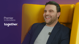 Dan Narwal laughing in a yellow chair with the Premier for Intermediaries logo to the left of him.